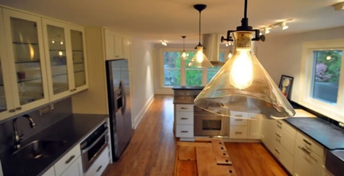 Residential electrician installing modern indoor light fixture in a home in Baltimore, MD
